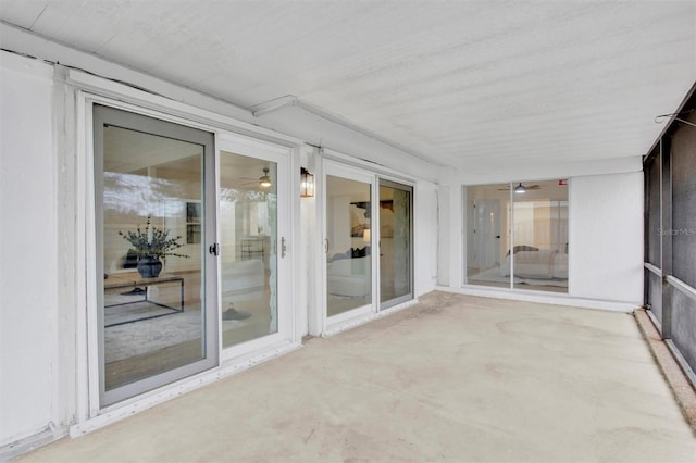 unfurnished sunroom featuring ceiling fan