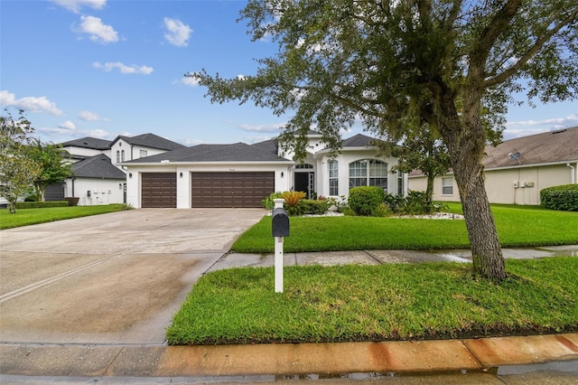 view of front of home featuring a garage, driveway, a front lawn, and stucco siding