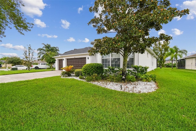 view of front facade with driveway, stucco siding, an attached garage, and a front yard