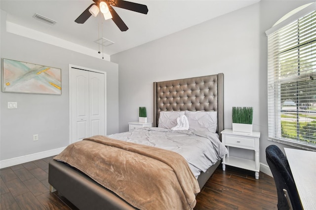 bedroom with baseboards, a closet, visible vents, and wood finished floors