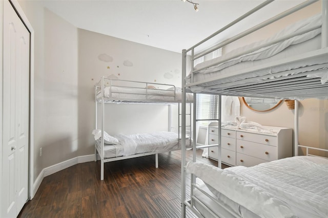 bedroom with a closet, baseboards, and wood finished floors