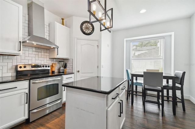 kitchen featuring electric range, dark wood-type flooring, wall chimney range hood, tasteful backsplash, and dark countertops