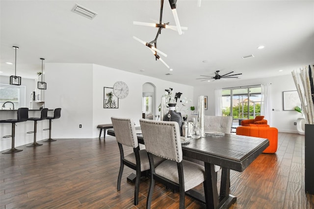 dining area featuring arched walkways, recessed lighting, wood finished floors, visible vents, and a ceiling fan