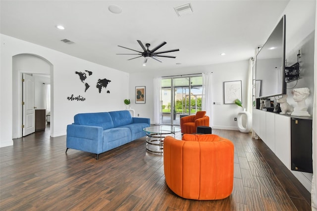 living area featuring dark wood-style floors, arched walkways, visible vents, and recessed lighting