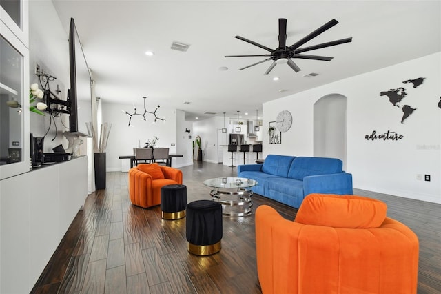 living room with arched walkways, visible vents, and wood finished floors