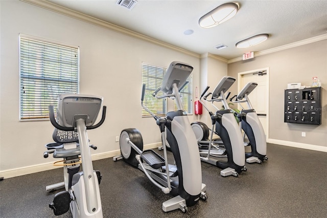 gym with ornamental molding, a healthy amount of sunlight, visible vents, and baseboards