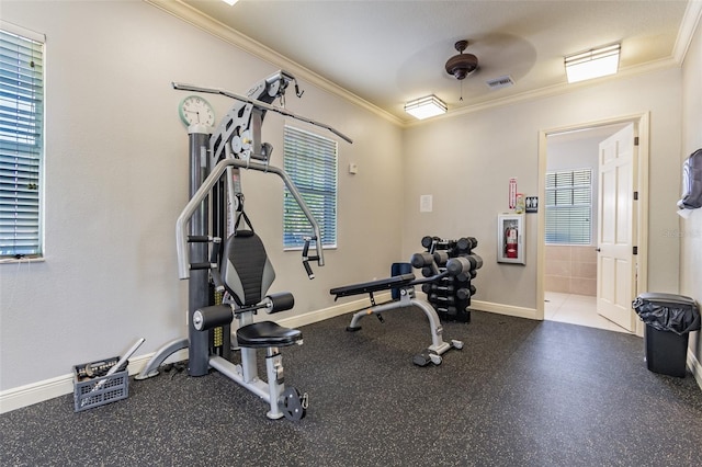 exercise area featuring baseboards, visible vents, and ornamental molding