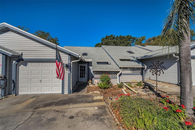 view of front of home featuring a garage, roof with shingles, and concrete driveway