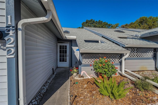 property entrance featuring a shingled roof