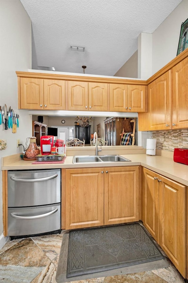 kitchen featuring dishwasher, light countertops, visible vents, and a sink