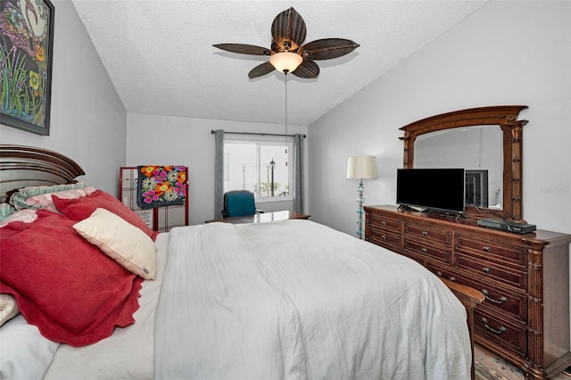 bedroom with lofted ceiling, a ceiling fan, and a textured ceiling