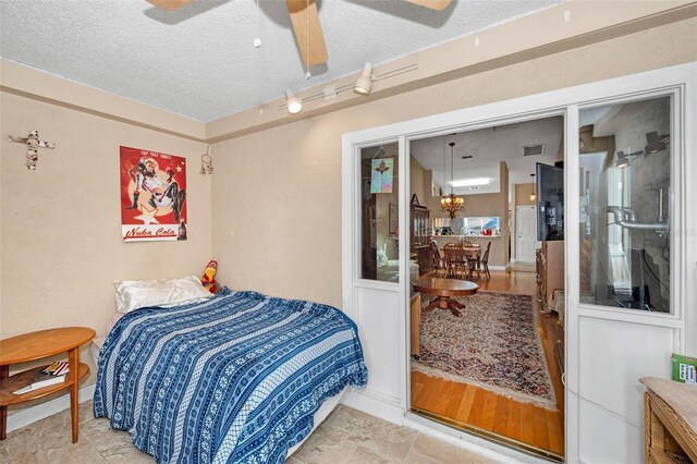 bedroom featuring visible vents, a textured ceiling, and baseboards