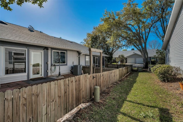 view of yard featuring central air condition unit and fence