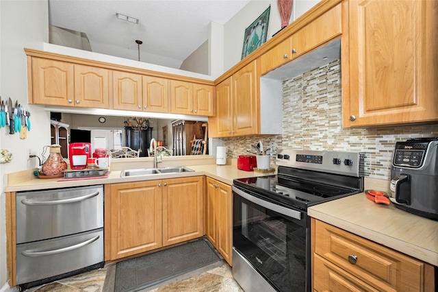 kitchen with light countertops, tasteful backsplash, stainless steel range with electric stovetop, light brown cabinetry, and a sink