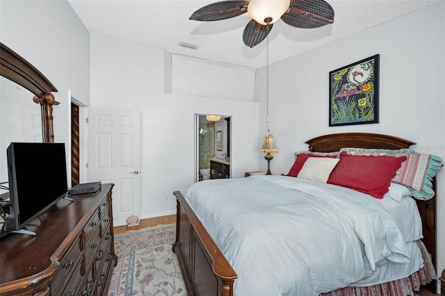 bedroom with a ceiling fan, a textured ceiling, light wood-style flooring, ensuite bathroom, and visible vents