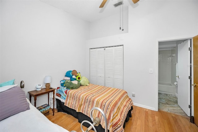 bedroom featuring a closet, light wood-style flooring, baseboards, visible vents, and ceiling fan