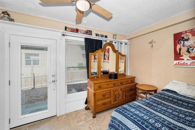 bedroom with ceiling fan and a textured ceiling