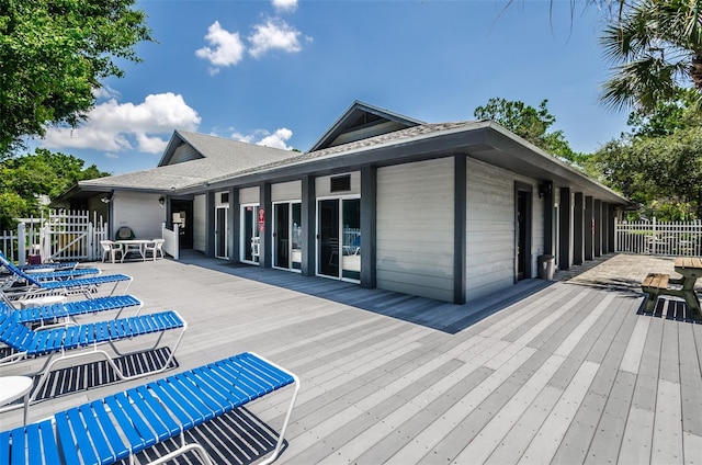 rear view of property featuring a deck and fence