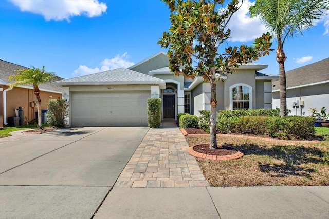 ranch-style house with driveway, a garage, and stucco siding