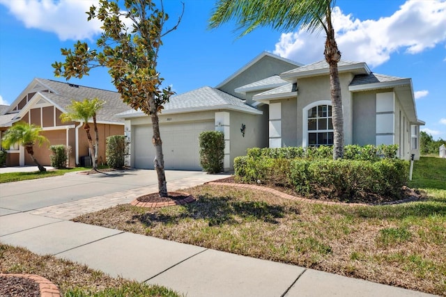 single story home featuring concrete driveway, an attached garage, and stucco siding