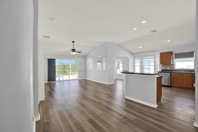 kitchen featuring dark wood-type flooring, dark countertops, dishwasher, and lofted ceiling