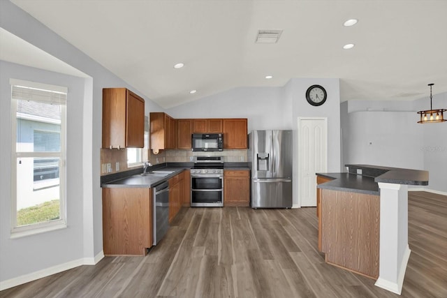 kitchen featuring tasteful backsplash, visible vents, dark countertops, appliances with stainless steel finishes, and a sink