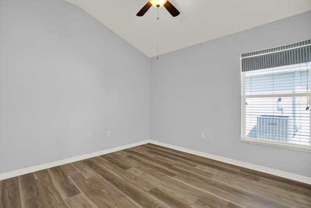 empty room with lofted ceiling, ceiling fan, baseboards, and wood finished floors