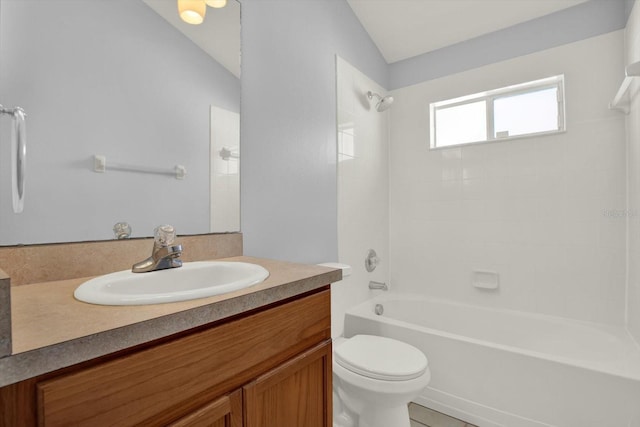 bathroom with toilet, vaulted ceiling, vanity, and washtub / shower combination