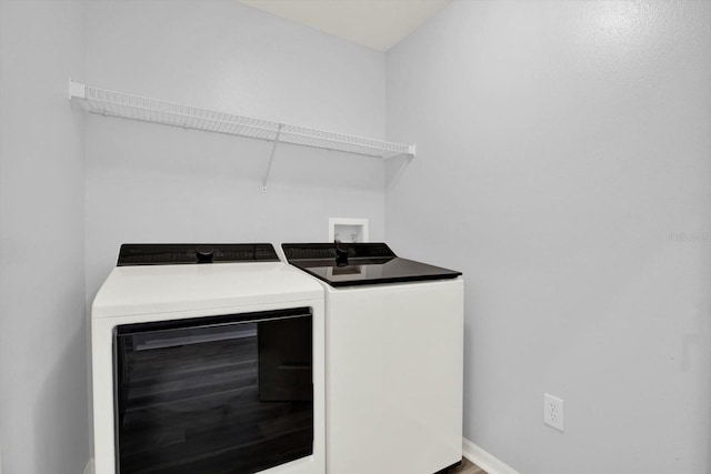 washroom with laundry area, baseboards, and separate washer and dryer