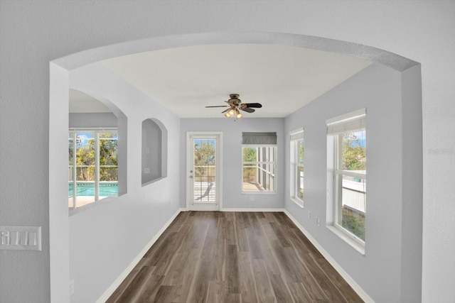 unfurnished sunroom with ceiling fan