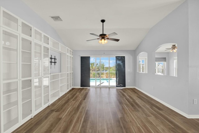 spare room featuring visible vents, vaulted ceiling, baseboards, and wood finished floors