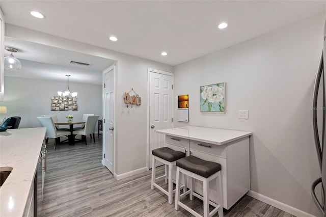 kitchen with light wood-style floors, a breakfast bar, and recessed lighting