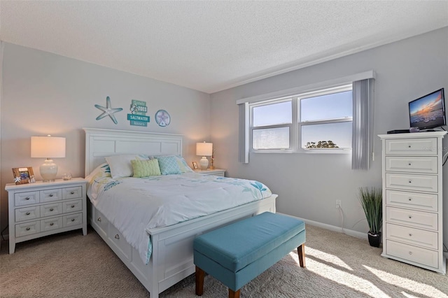 bedroom featuring light carpet, baseboards, and a textured ceiling