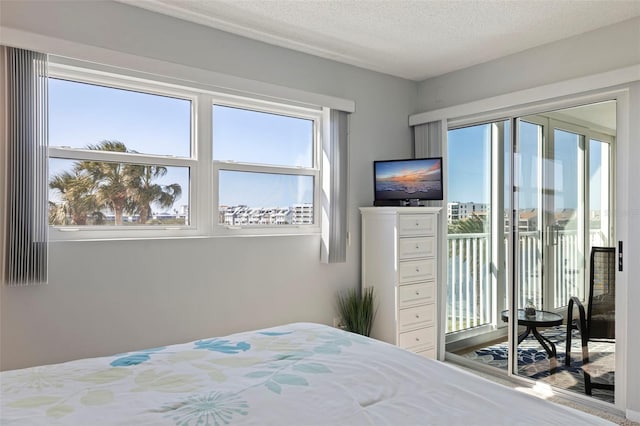 bedroom with a textured ceiling and access to exterior