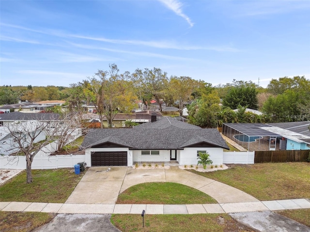 view of front of property with a shingled roof, an attached garage, a front yard, fence, and driveway