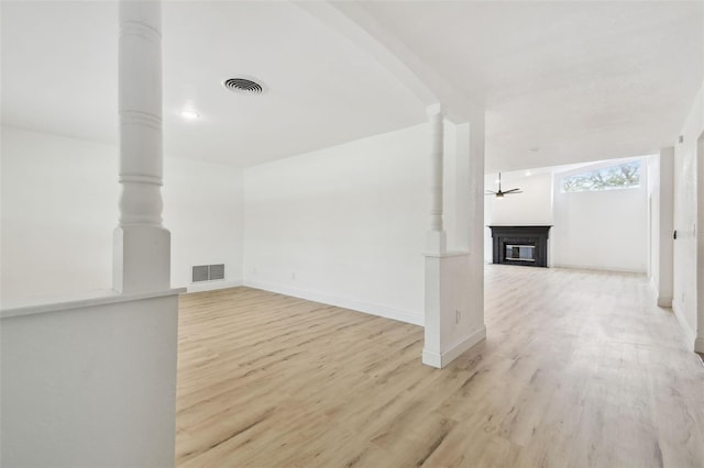 bonus room featuring light wood-type flooring, visible vents, and a glass covered fireplace