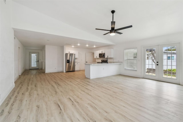 unfurnished living room with light wood-type flooring, lofted ceiling, french doors, and ceiling fan