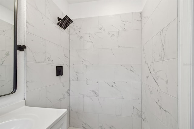 full bath featuring a tile shower and vanity