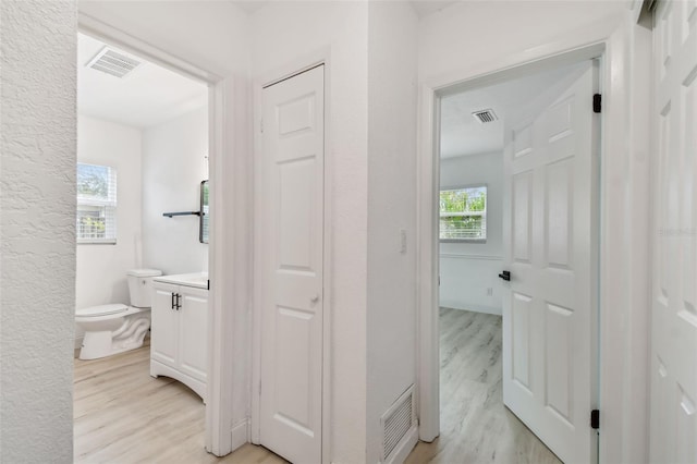 bathroom featuring toilet, wood finished floors, and visible vents