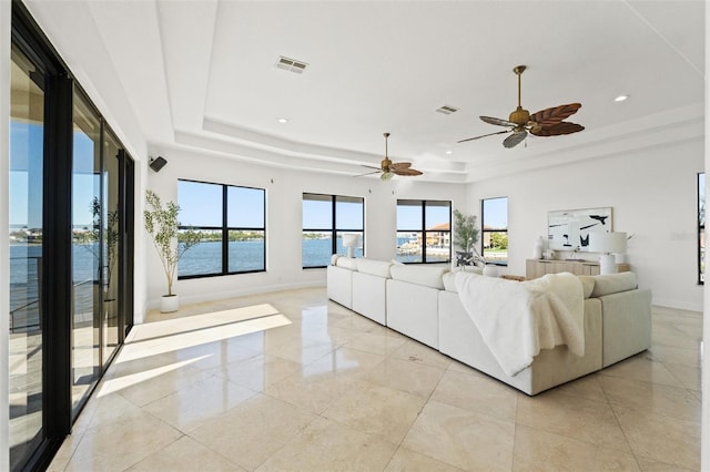 unfurnished living room featuring recessed lighting, visible vents, a raised ceiling, and baseboards