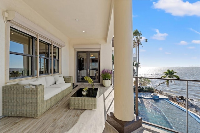 balcony featuring outdoor lounge area and a water view