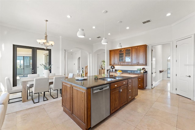 kitchen with visible vents, dishwasher, an island with sink, arched walkways, and a sink