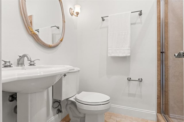 full bathroom with toilet, baseboards, a tile shower, and a sink