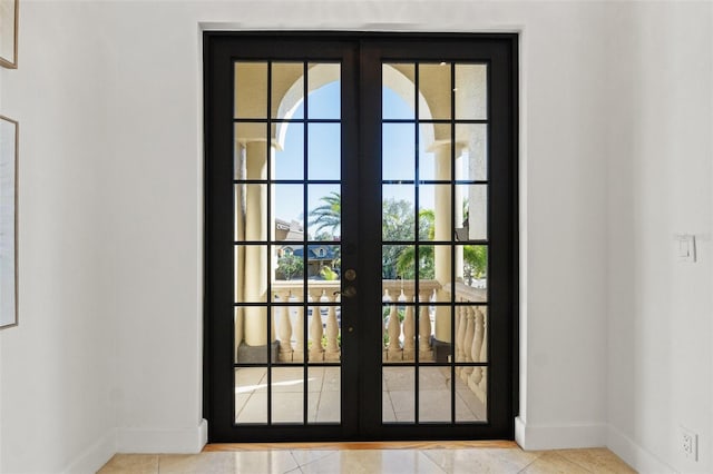 doorway with french doors and baseboards