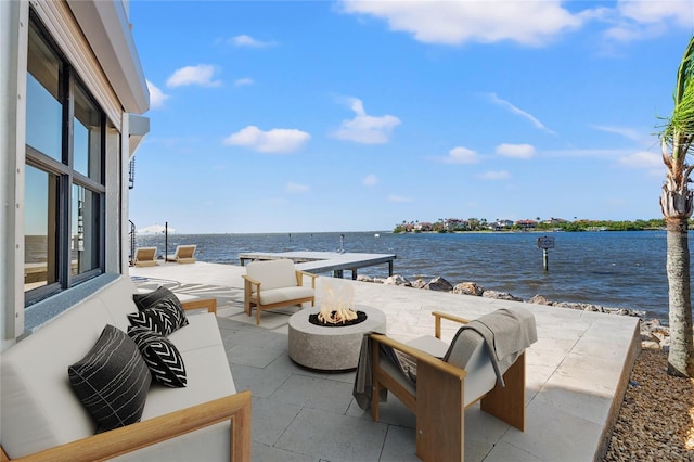 view of patio with a water view and a fire pit