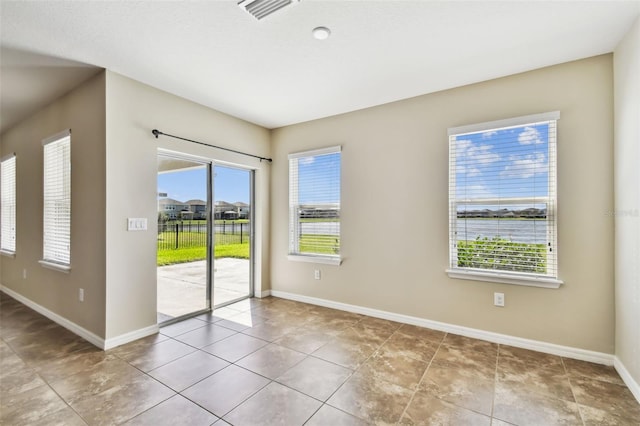 tiled spare room with visible vents and baseboards