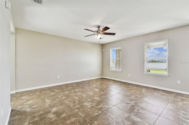 unfurnished room with visible vents, baseboards, and a ceiling fan