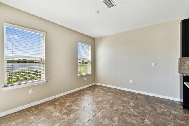 unfurnished room with visible vents and baseboards