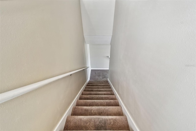 stairway featuring carpet flooring and baseboards