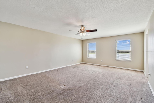 carpeted empty room featuring a textured ceiling, baseboards, and a ceiling fan